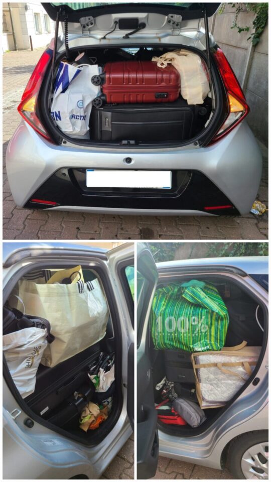 A car packed to the brim with luggage, filling both the trunk and backseat. 트렁크와 뒷좌석까지 짐으로 가득 찬 자동차.