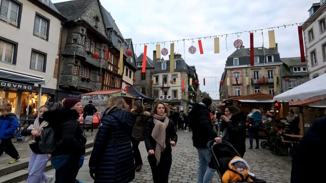 A wide-angle view of Place du Centre Christmas Market, filled with festive decorations and people enjoying the holiday spirit. 크리스마스 장식과 축제 분위기로 가득한 Place du Centre 크리스마스 마켓의 전경.
