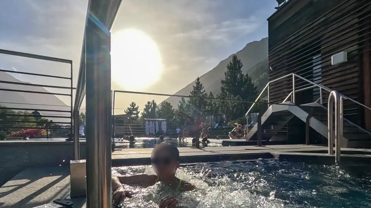 A contrast between the quiet spa and the lively infinity pool at QC Terme Chamonix, with the sun setting over the mountains. QC Terme Chamonix의 스파와 인피니티풀이 대조적인 모습을 보이는 장면, 산 위로 해가 지는 풍경