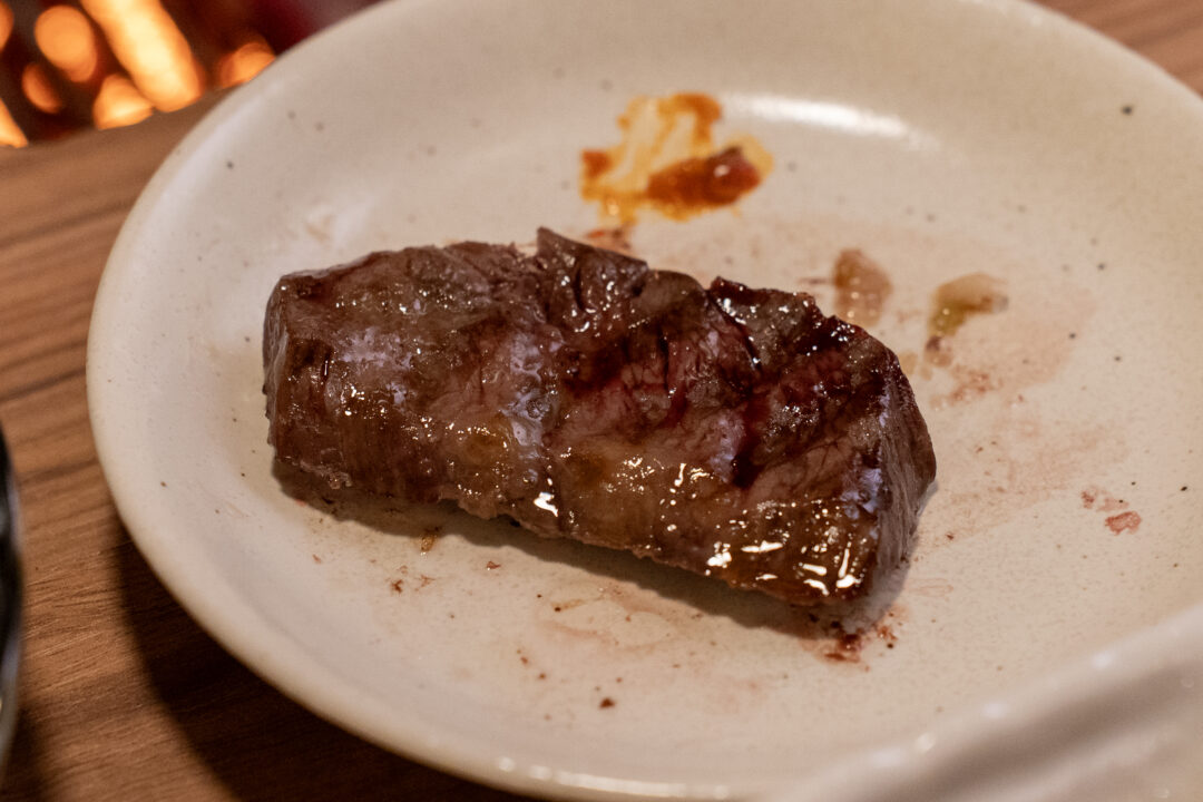 Cooked garlic skirt steak with sauce. 갈릭 안창살 한 점, 소스와 함께