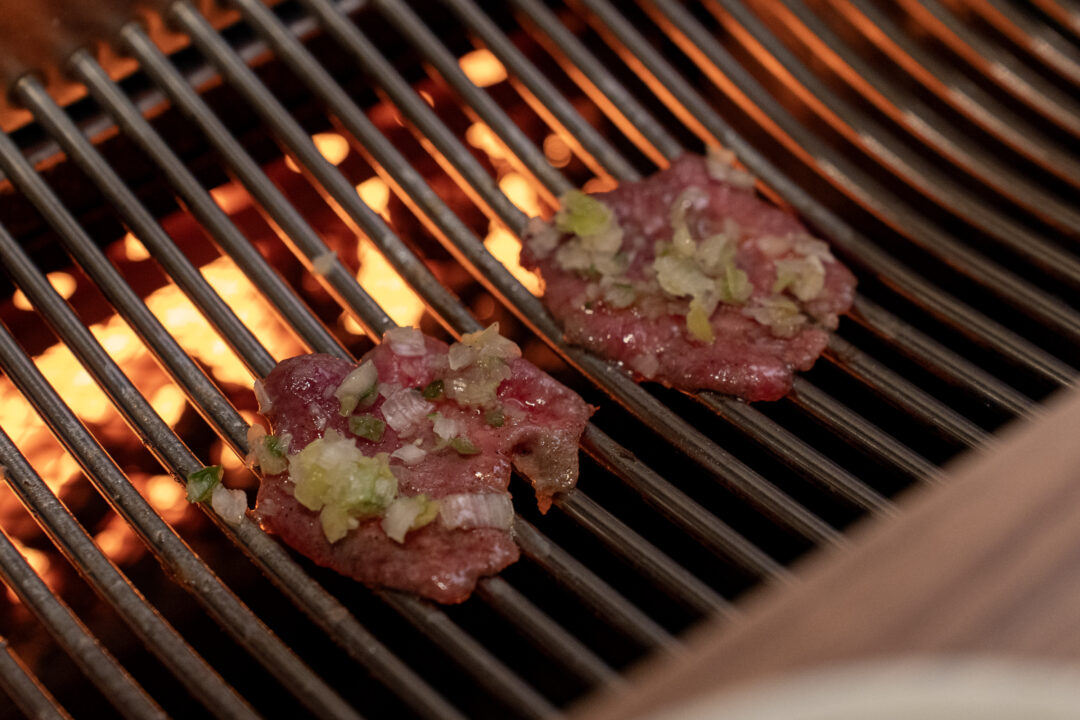 Beef tongue topped with green onion on the grill. 파를 올린 우설을 굽는 장면