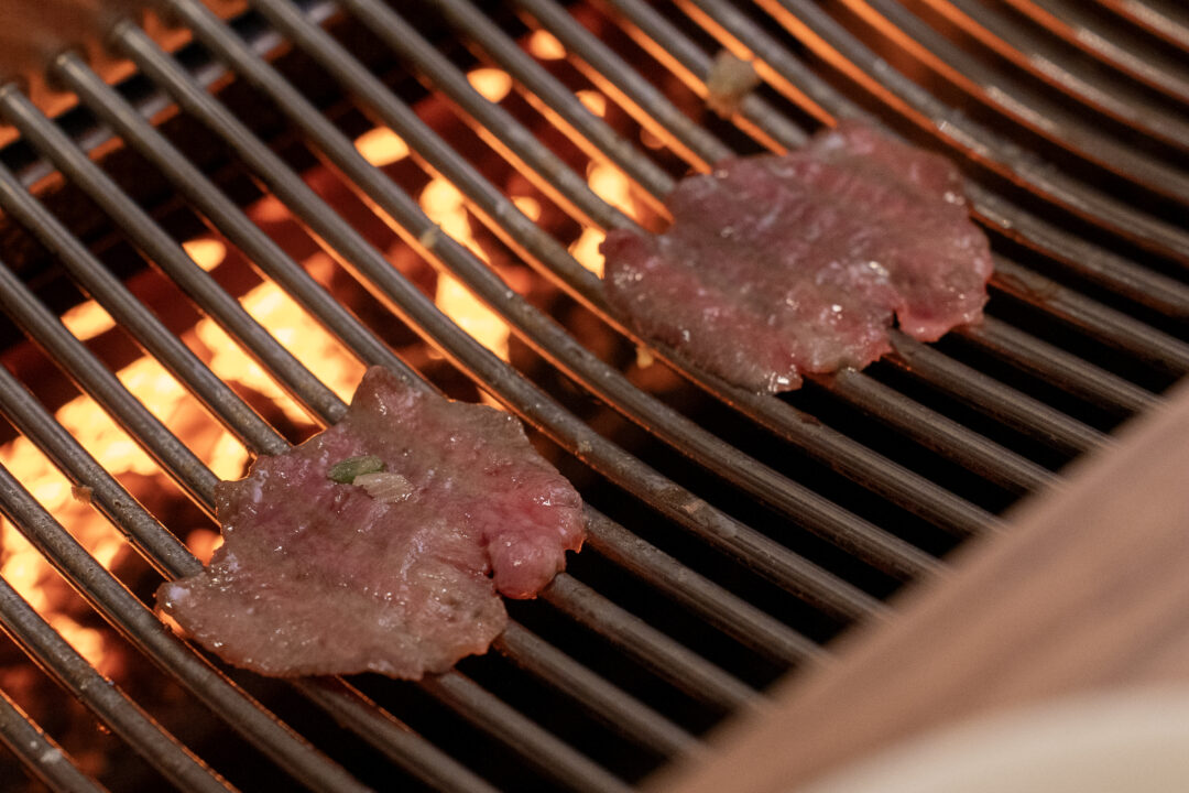 Thin slices of beef tongue grilling over fire. 불 위에서 구워지는 얇은 우설