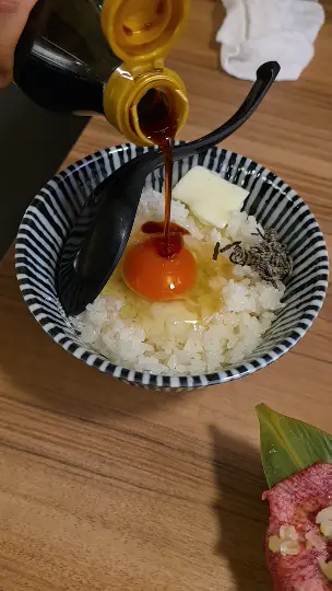 Pouring special soy sauce over raw egg rice bowl (TKG) at Yakiniku Inyen. 신사이바시야키니쿠 인연에서 생계란밥(TKG) 위에 특제 간장을 붓는 모습.