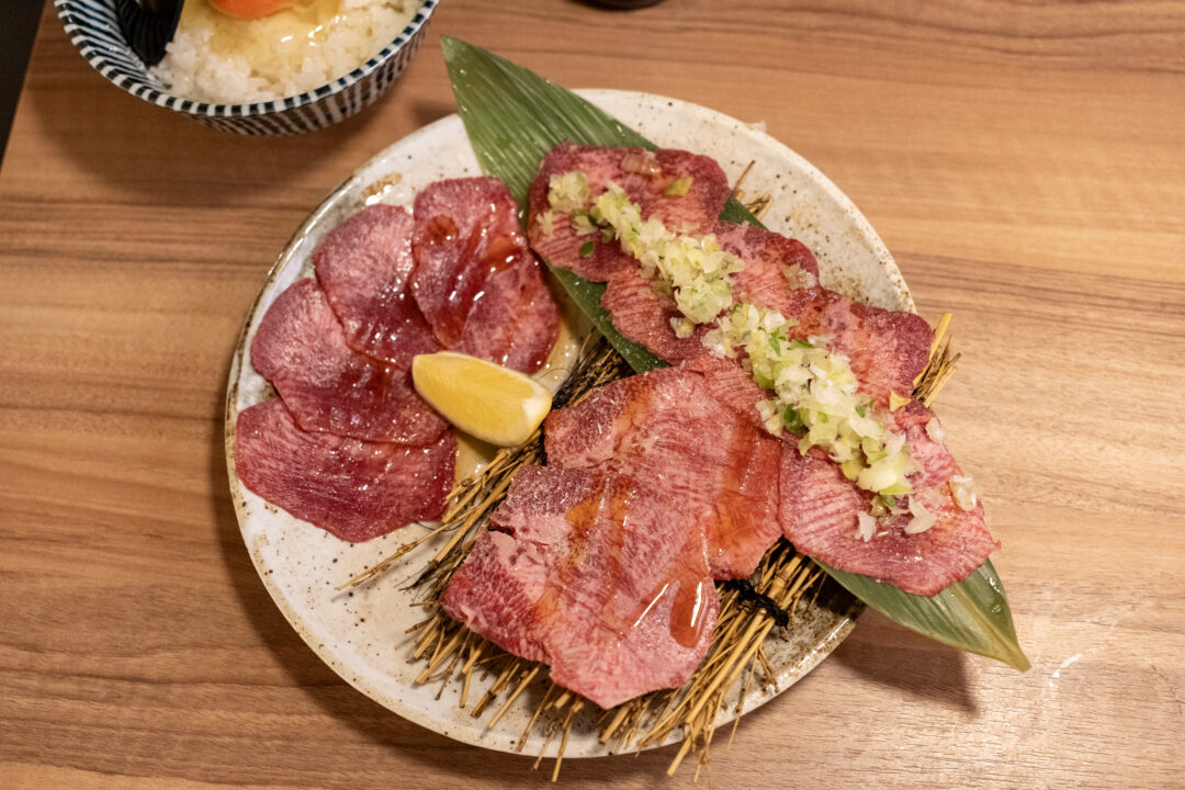 Platter of three different beef tongue cuts at Yakiniku Inyen - thick slices, thin slices, and tongue with green onion topping. 신사이바시야키니쿠 인연의 우설 3종 세트 - 두꺼운 우설, 얇은 우설, 파 고명이 올라간 우설.